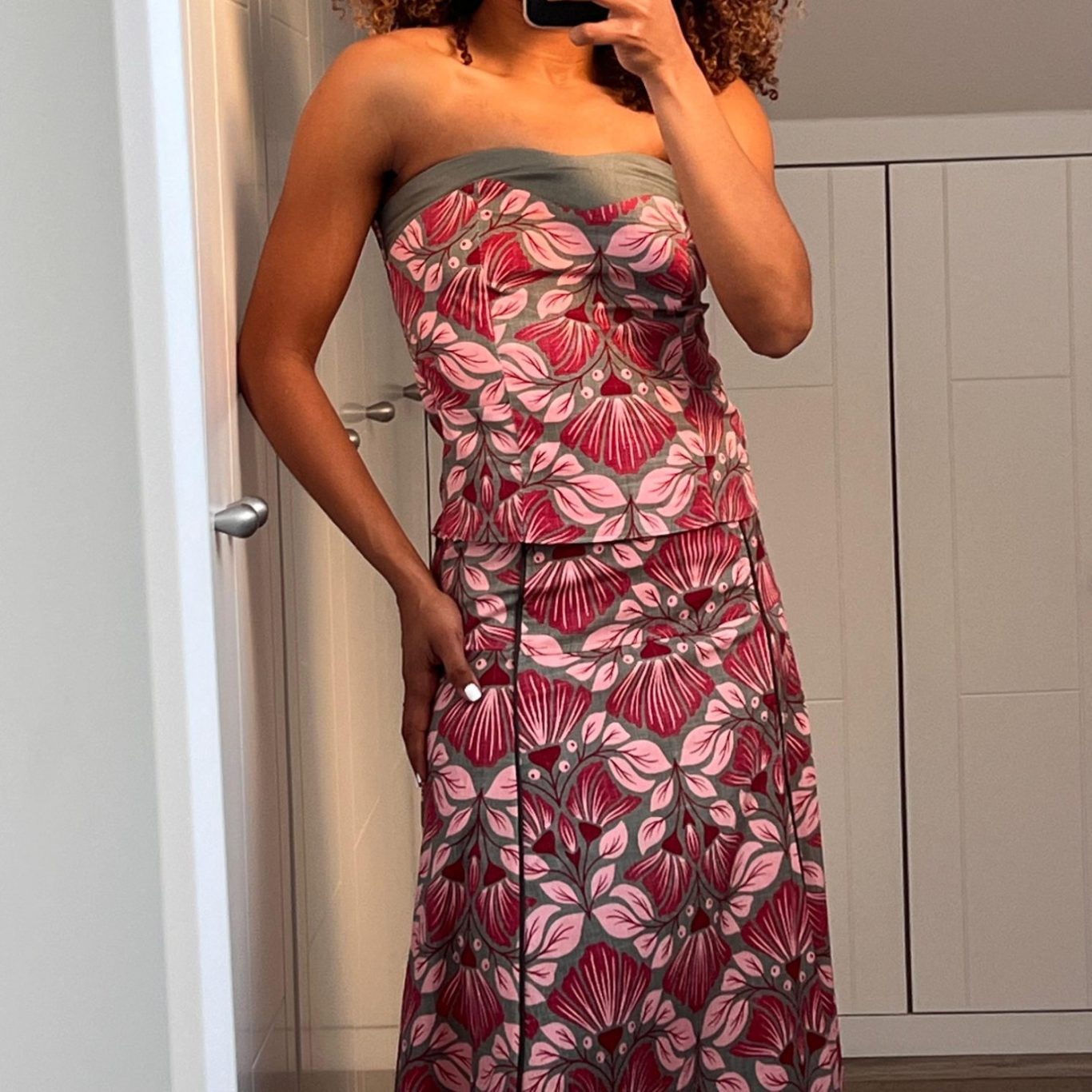 VESTIDOS Mujer sonriendo, vestida con un vestido largo de estampado marrón y negro.